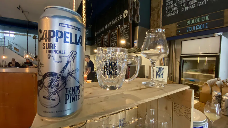 A beer can is placed on a table next to a beer glass.